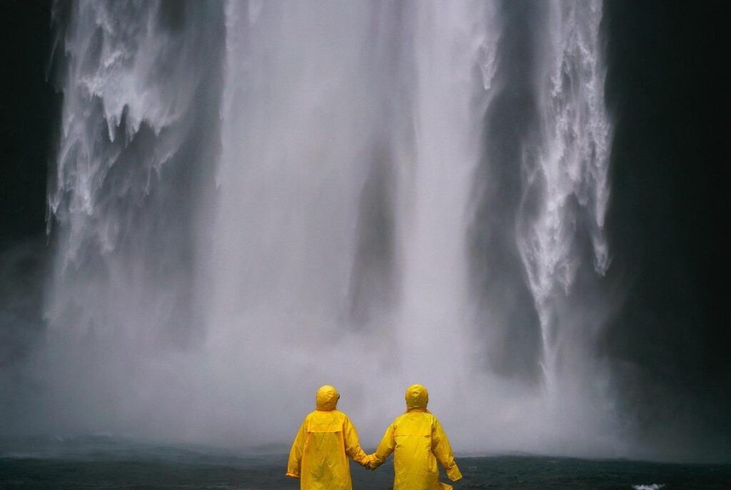 Couple at huge waterfall holding hands