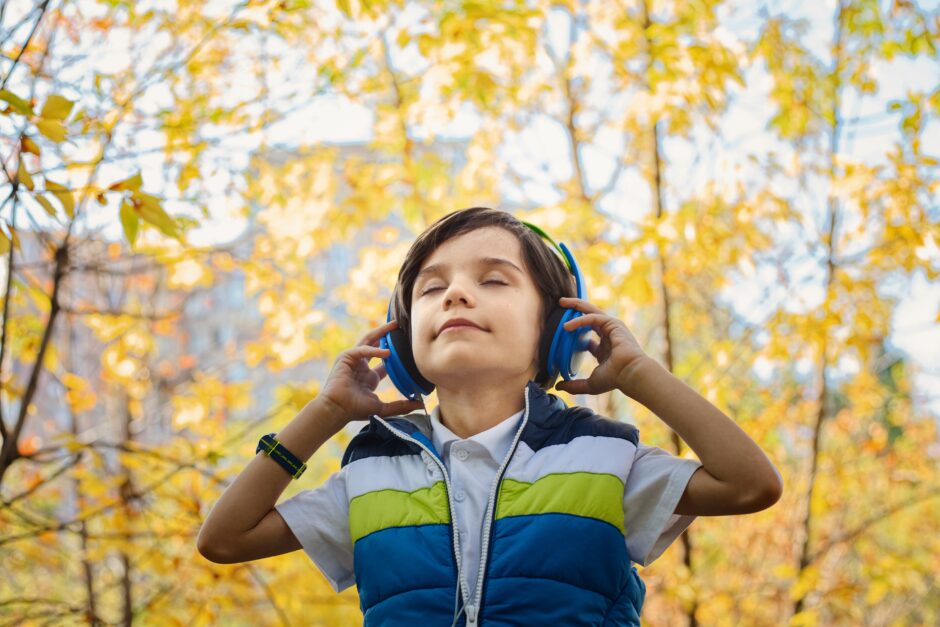 Boy smiling while listening to music nurtures his soul.