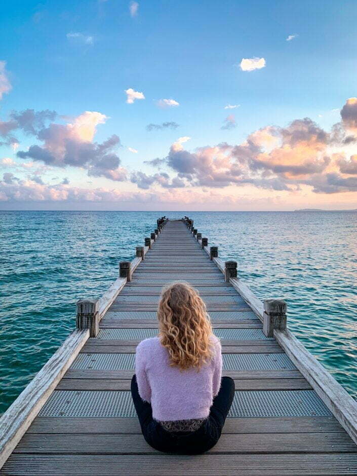 Woman meditating on a wharf When life gives you lemons make lemonade