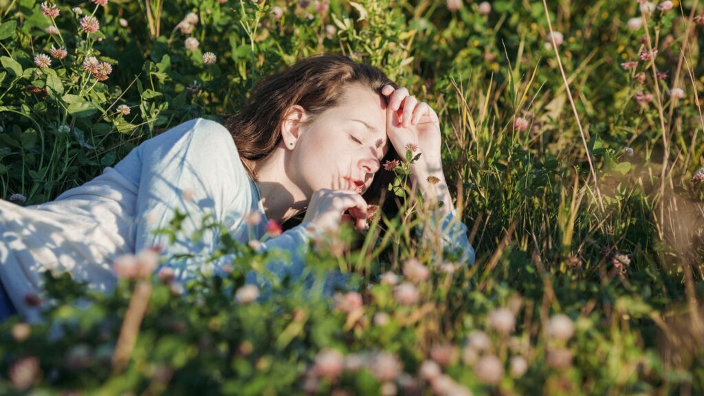 Sleeping woman in flowers is dreaming during the day. Dreamwork helps her understand her dream's wisdom.