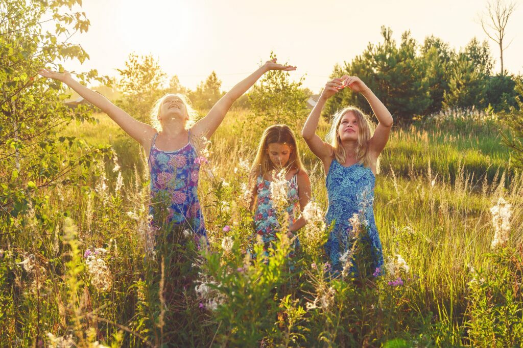 Three joyful girls in wildflowers. Bach Flowers are great for children!