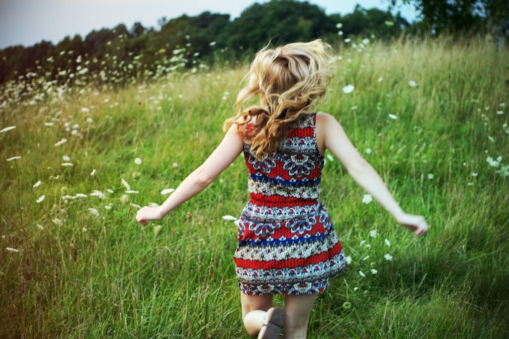 Girl running in field of flowers