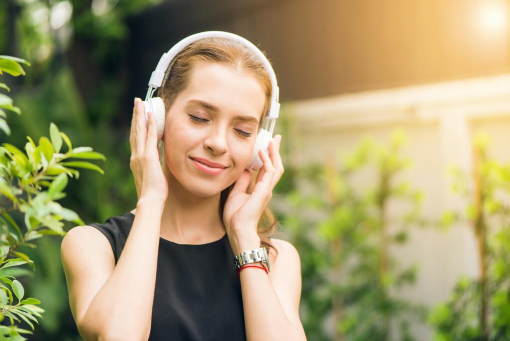 Happy woman listening to music. Music therapy is an integrative medicine therapy.