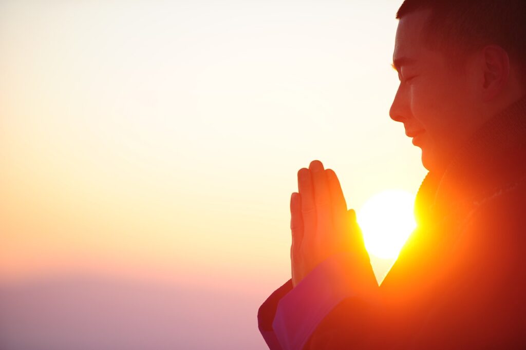 A reverent man does yoga meditation at sunrise.