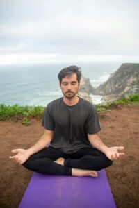 Man meditating in nature peacefully. Meditation enhances dreamwork.